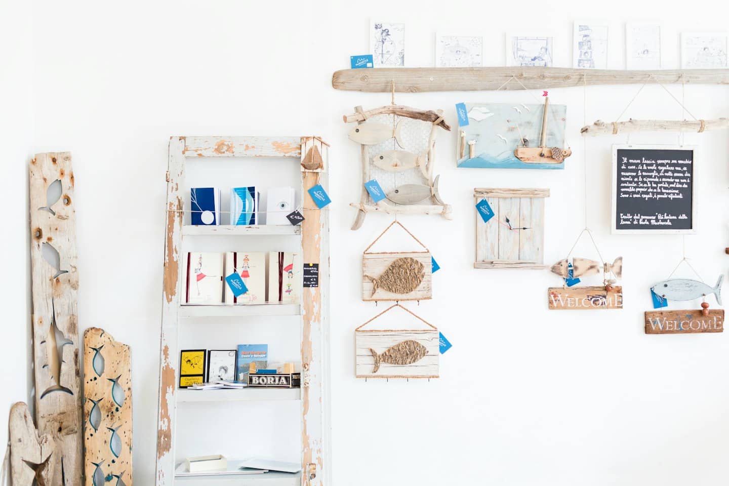 Coastal-themed shop display with wooden fish and merchandise.