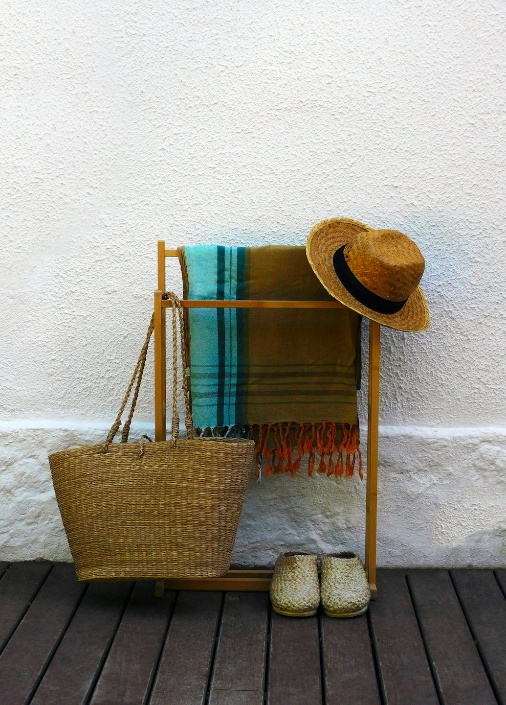Beach accessories hanging on a wooden rack against a wall.