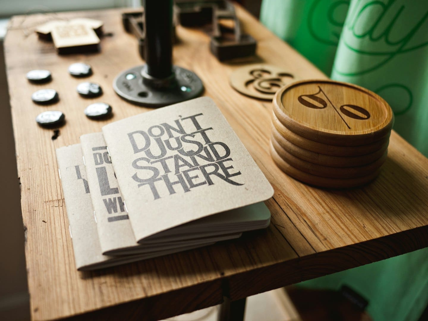 Kraft paper notebooks and coffee coasters on a wooden table.